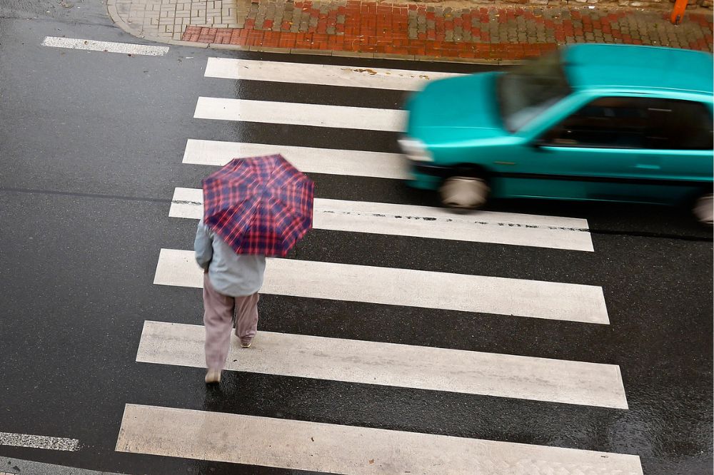 Chodec je na přechodu pro chodce současně s projíždějícím autem